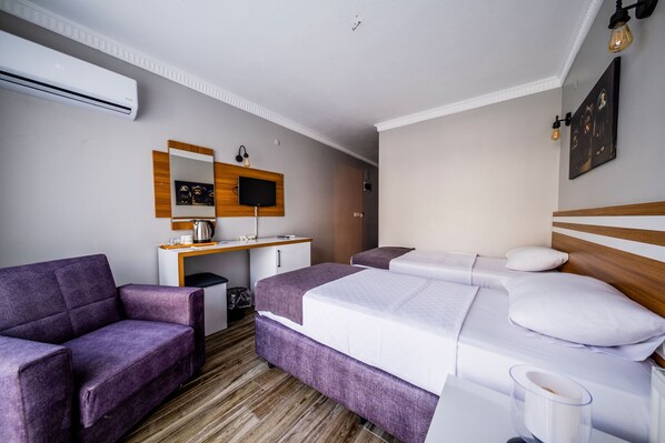 A hotel room with a bed, a sofa, a desk with a computer, and a TV. - Lopera Beach Hotel (Edremit)