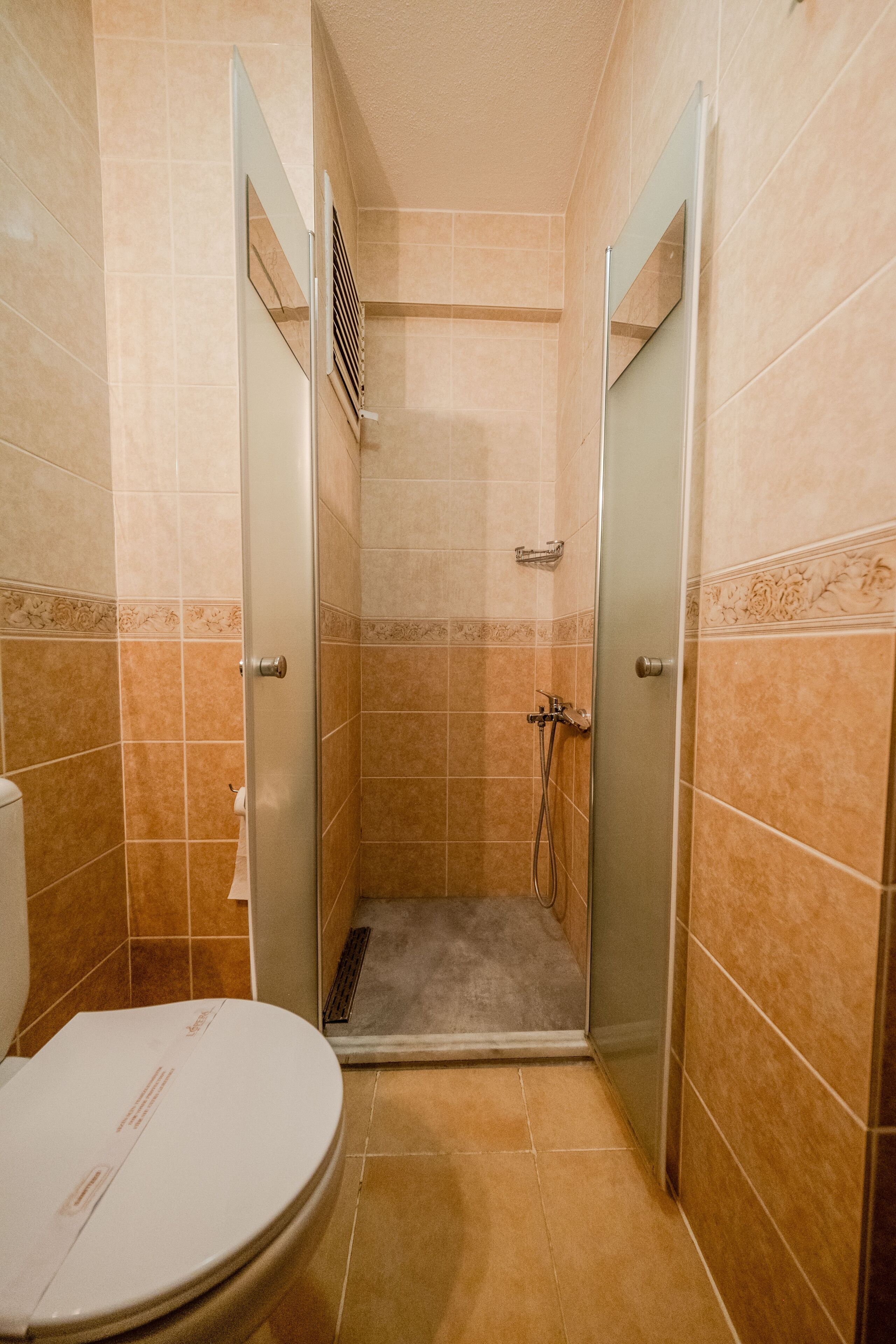 A bathroom with a shower, toilet, and sink.