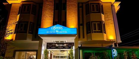 Entrada de un hotel con un cartel que dice 'L'OPERA BEACH HOTEL'.