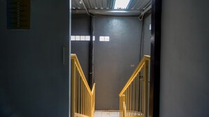 A narrow stairway with wooden railings leading to a landing. - OYO 93682 Blessing's Kediri Homestay Syariah (Kediri)