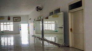 A spacious, well-lit room with a large window, a ceiling fan, and a door. - OYO 93682 Blessing's Kediri Homestay Syariah (Kediri)
