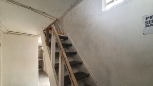 A staircase in a building with a sign on the wall. - SPOT ON 93681 Qodri Homestay Syariah (Surabaya)