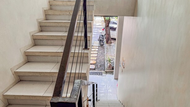 A staircase with a metal railing leading to a street. - Hotel O Kost Naura (Somba Opu)