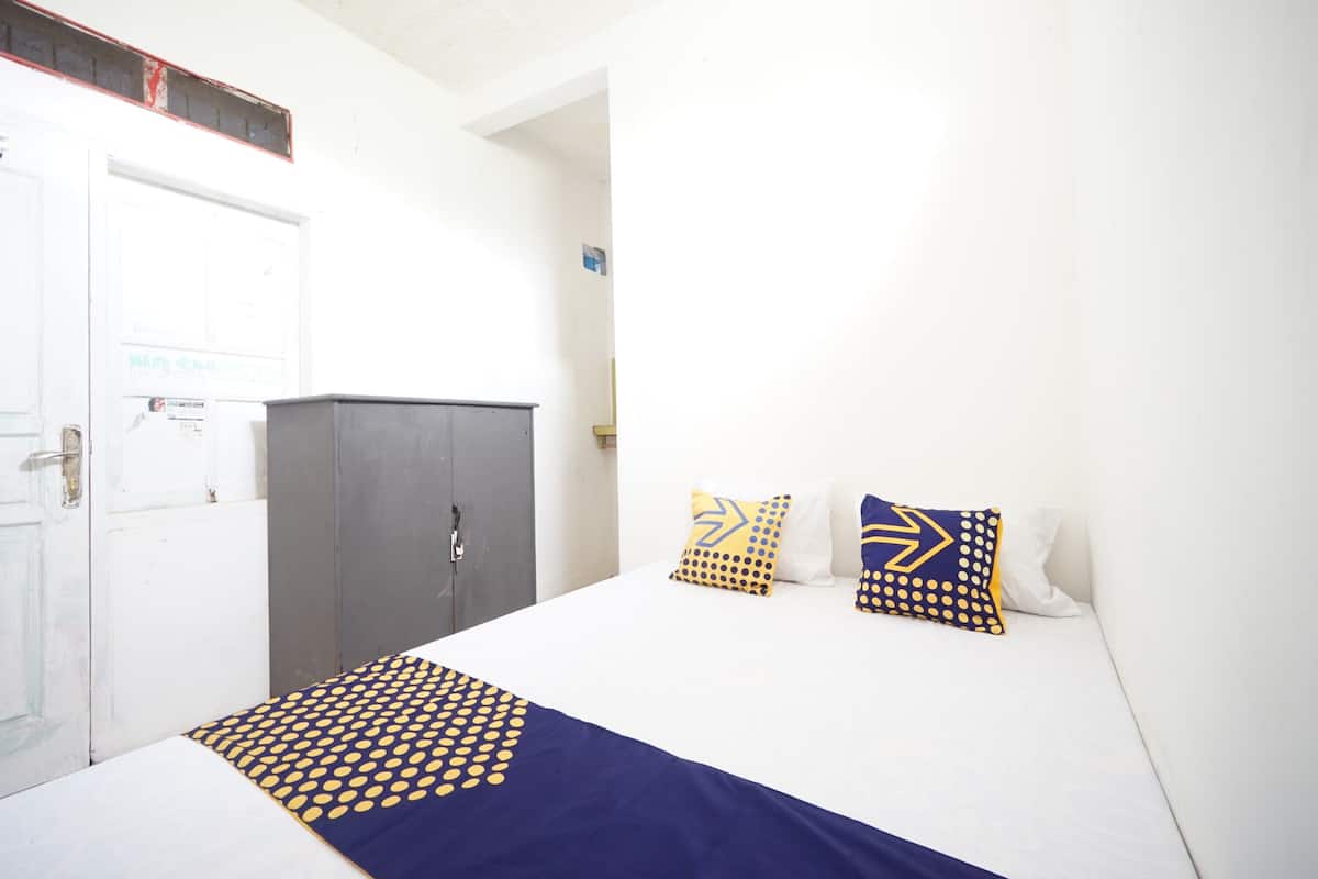 Una habitación de hotel con cama, armario y puerta.