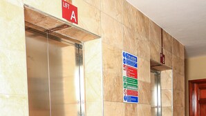 A corridor with two elevators, each marked with a lift sign indicating their respective floors. - South Suites Studios (Nairobi)