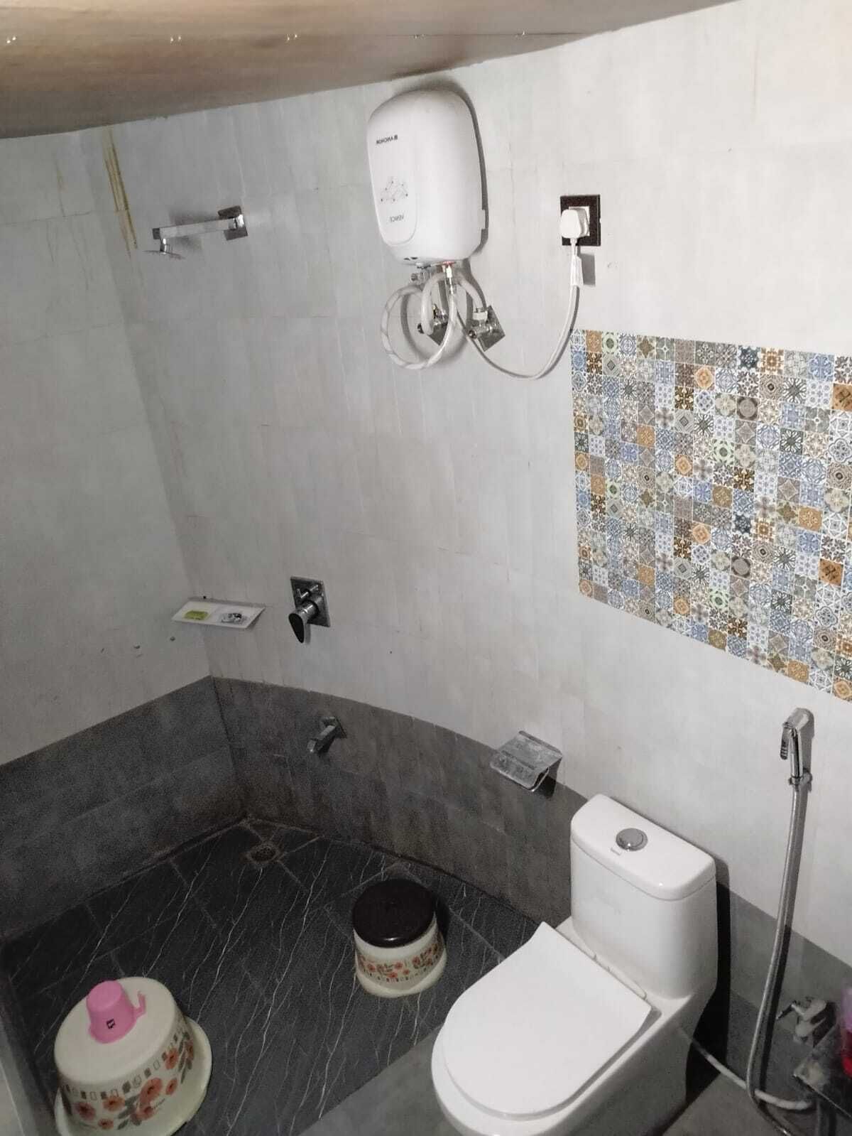 A bathroom with a shower, toilet, and a sink.