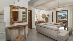 Ein modernes Wohnzimmer mit einer großen Couch, einem Holztische und einem Spiegel.