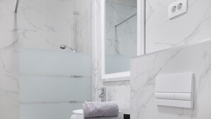 Un bagno moderno dotato di doccia, servizi igienici e lavabo.