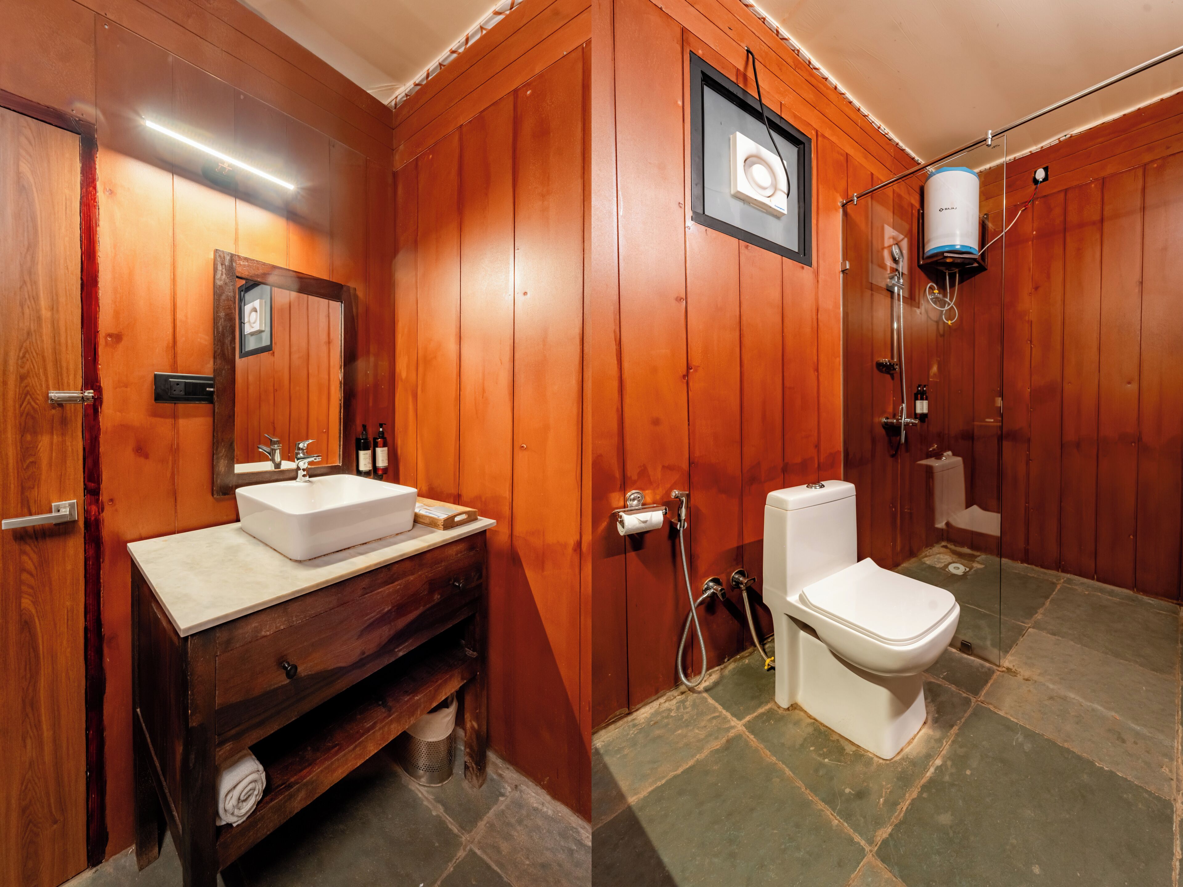 A wooden-paneled bathroom with a sink, toilet, and shower.