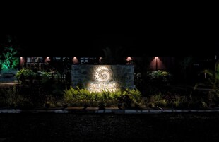 Vista nocturna de un letrero que dice 'Candi Sagar Forest Resort'.