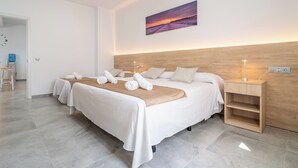 Ein modernes Hotelzimmer mit einem großen Bett, einem Holzkopfstück und einem Sonnenuntergangsbild.