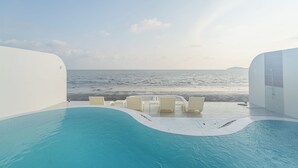 A pool area with a view of the sea, white walls, and a few lounge chairs. - Aadhitiya Private Pool Villas (Tha Mai)