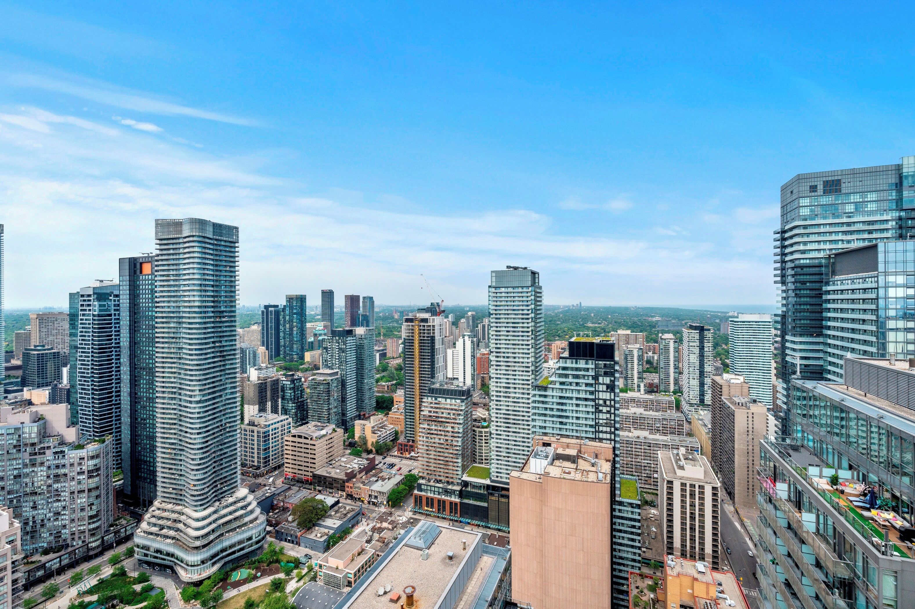 Un paysage urbain caractérisé par de nombreux immeubles de grande hauteur et une architecture moderne, notamment un bâtiment remarquable à la forme incurvée et plusieurs gratte-ciel.