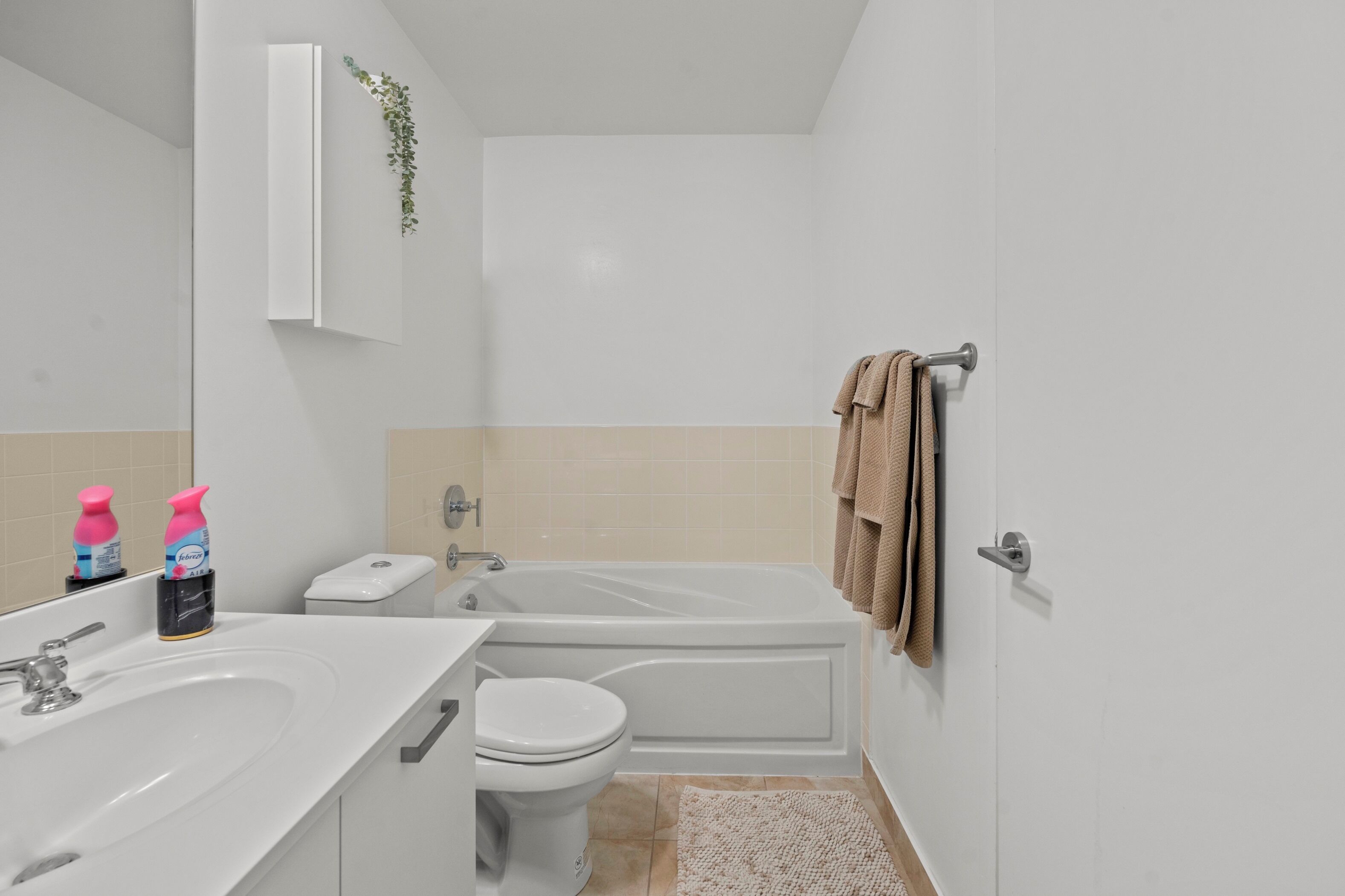 Un baño con lavabo blanco, inodoro y bañera. Hay dos jabones sobre el lavabo.