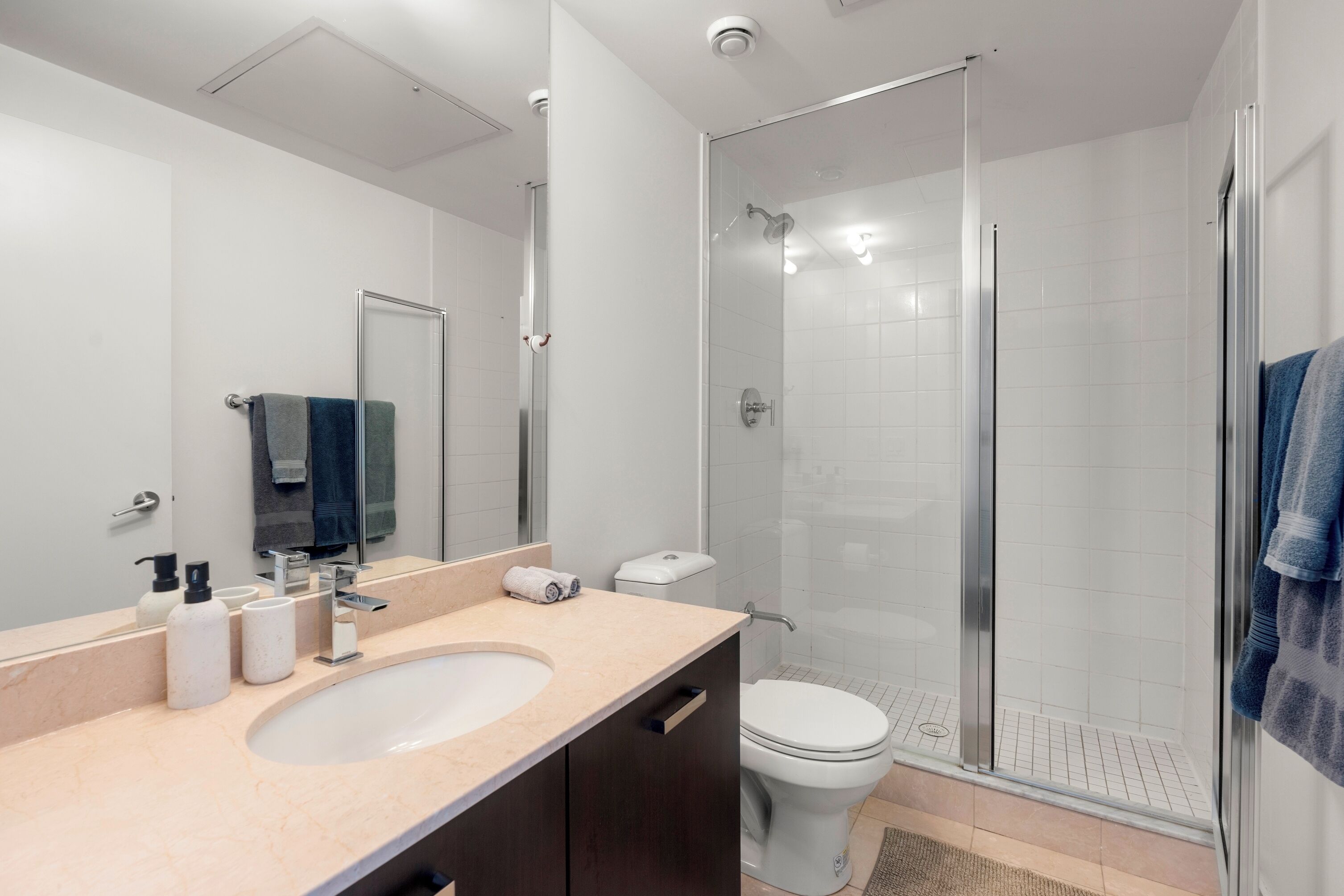 Une salle de bain moderne avec un lavabo, un miroir et une douche à parois de verre.