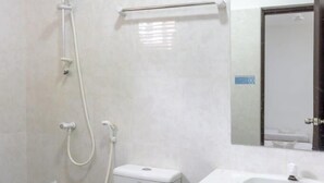 A bathroom with a toilet, a sink, and a shower. - Surf Trip Maldives (Thulusdhoo Island)