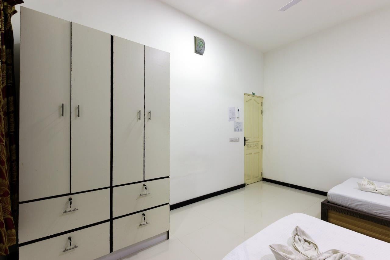 Ein Zimmer mit großem Kleiderschrank, einem Bett und einer Tür.