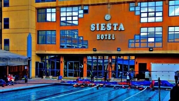 A hotel with a swimming pool, a sign reading "SIESTA HOTEL," and multiple balconies. - New Siesta Hotel  (Alexandria)