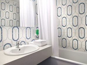 Ein Badezimmer mit einem weißen Waschbecken, einem Spiegel und einem Handtuchhalter.