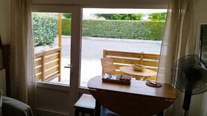 Ein Zimmer mit einer Schiebeglasdoor zu einem Sitzbereich im Freien, inklusive Tisch und Stühlen.