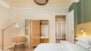 A bedroom with a bed, a chair, a wardrobe, and a lamp. - Margarita by halu! 3-BD tropical house (Thessaloniki)