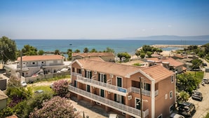 Una zona residencial costera con un edificio de dos pisos destacado, que cuenta con un balcón y vistas al mar.