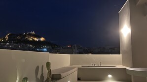 A rooftop terrace with a modern design, featuring a pool, a cactus garden, and a view of a cityscape at night. - Design Penthouse with Hot Tub and Private Rooftop In Exarhia Athens (Athens)