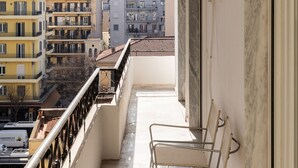 A balcony with metal chairs, a white door, and an air conditioning unit. - Sunflower by halu! Apartments (Thessaloniki)