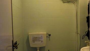 Een badkamer met een toilet, bidet en wastafel.