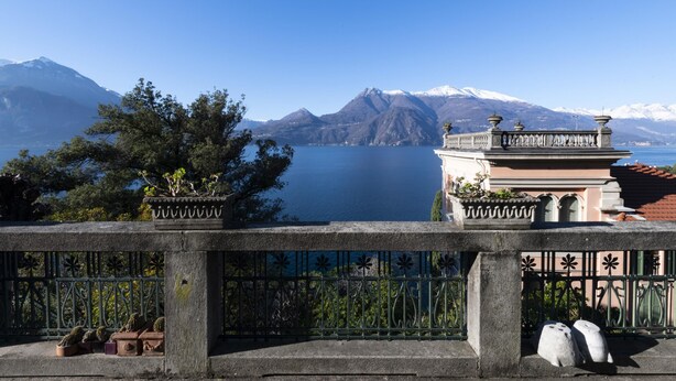 Un balcon avec vue sur un lac et des montagnes.