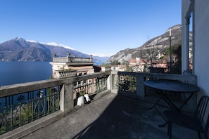 A balcony with a view of a lake and mountains.