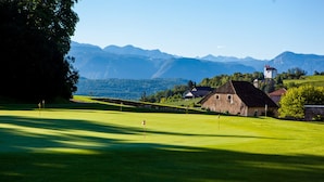 A golf course with a stone building and a tower in the background. - Ansitz Zinnenberg (Appiano Sulla Strada del Vino)