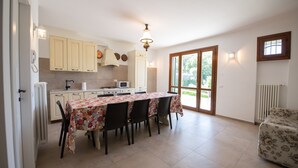 Eine geräumige Küche mit Esstisch, Stühlen und einer Couch.