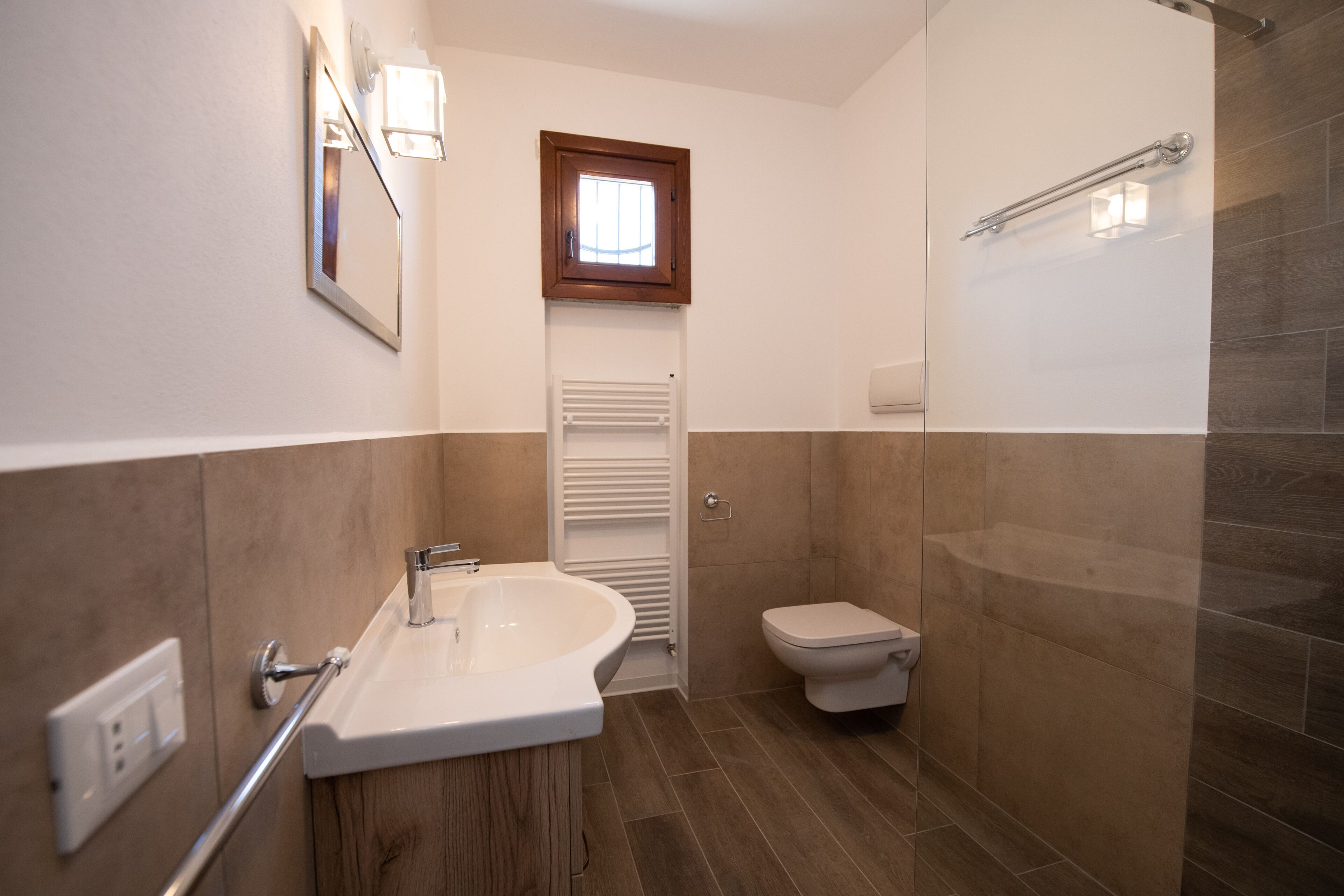 Une salle de bain comprenant un lavabo, des toilettes et un espace douche.