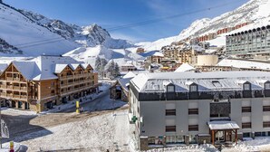 A snow-covered mountain town with wooden buildings and a ski lift.