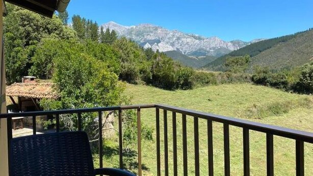 A balcony with a glass table and chairs, overlooking a mountainous landscape. - Vivienda 2 Personas Finca Malvasia (Cabezón de Liébana)