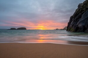 A beach with calm waters and a sunset. - Cottage in Ballintoy, Causeway Coast - sleeps 5 (Ballintoy)