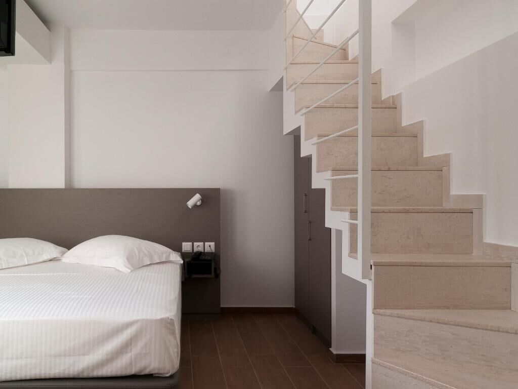 Une chambre à coucher moderne avec un lit, une table de chevet et un escalier.