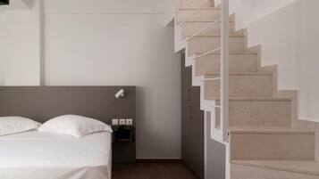 Une chambre à coucher moderne avec un lit, une table de chevet et un escalier.