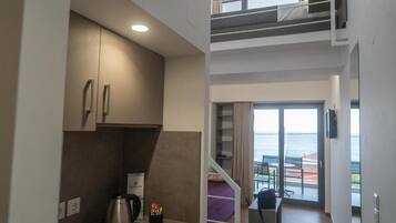 Quarto de hotel compacto com cozinha compacta, varanda com vista e beliche.