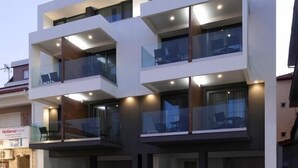 Un edificio moderno de varios pisos con balcones, ventanas amplias y techo plano.