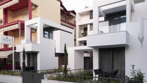 Un hotel moderno con fachadas blancas, balcones y terrazas al aire libre.