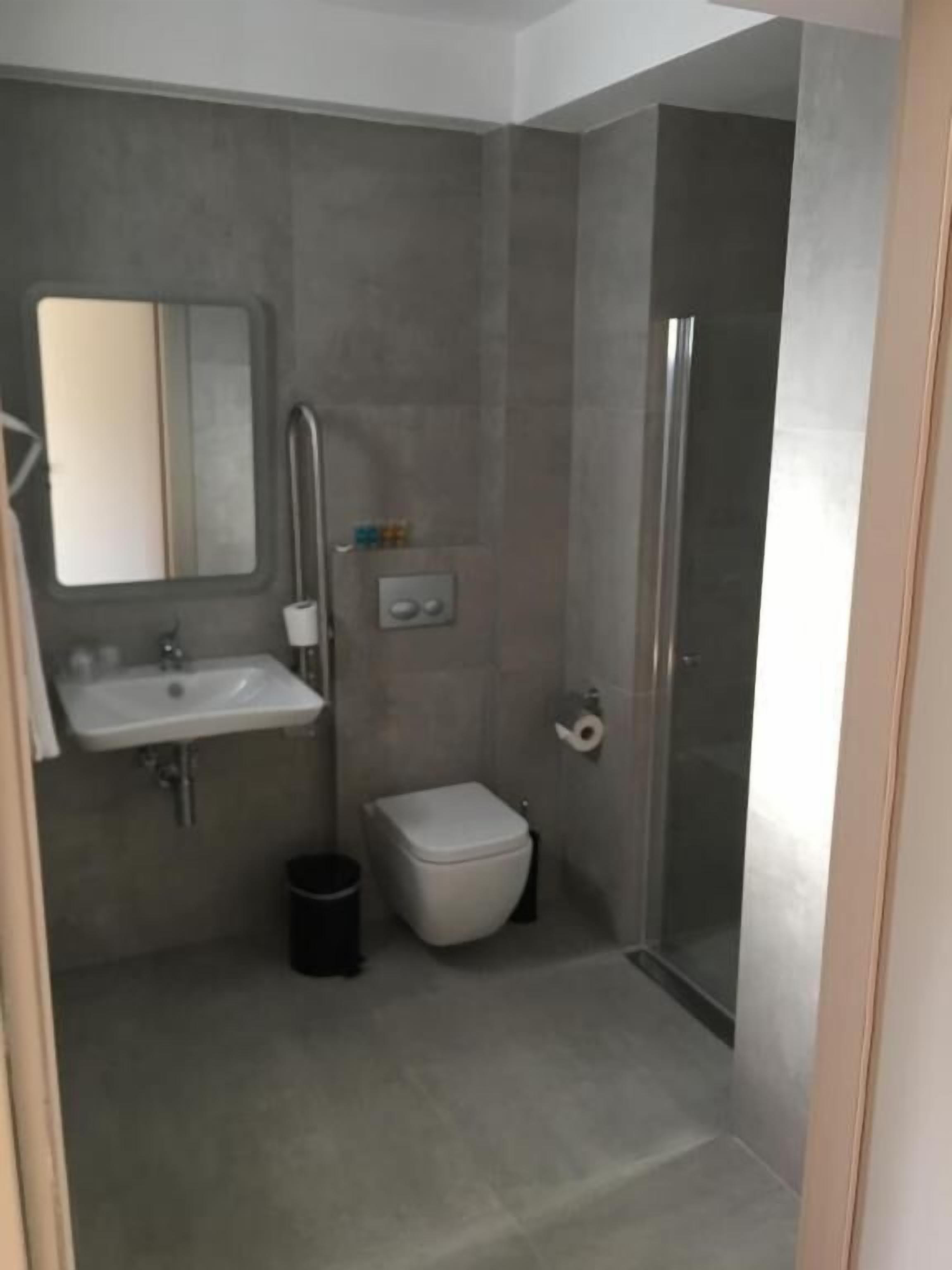 A modern bathroom with a sink, toilet, and shower.