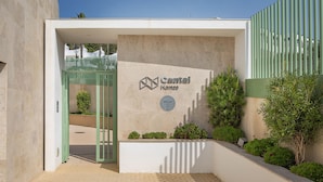 A modern building entrance with a sign for 'Cantal Homes' and a gated driveway.
