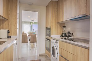 Appartement | Privékeuken | Een koelkast met diepvriezer, een microgolfoven, een oven, een kookplaat