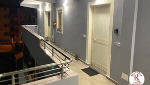 Un interior modern amb una escala, una porta amb ull i una finestra petita amb un extintor.