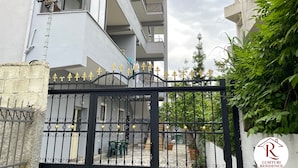 Edifici residencial amb porta tancada, balcó, escala i plantes en testos.