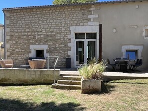 Relax in the outdoor seating area with wicker chairs and a table, perfect for taking in the surroundings.