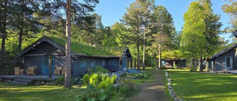 Rivi olkikattoisia mökkejä, joiden ympärillä on metsä.