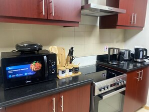 A kitchen with a microwave, coffee maker, and oven.